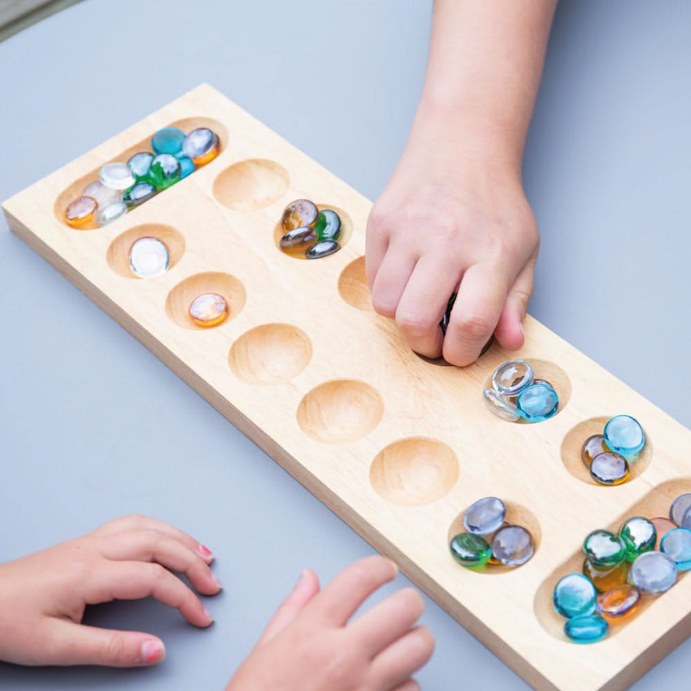 Mancala, Mancala,Bigjigs Mancala Game,Wooden Mancala Game,Counting Game, Bigjigs Mancala Game – A Classic Strategy Game for All Ages! Experience the timeless fun of Mancala, a strategic two-player board game that has been enjoyed for centuries. The Bigjigs Mancala Game combines tactical thinking, counting skills, and strategy, making it a perfect family-friendly game for players of all ages. Crafted from high-quality, responsibly sourced wood, this beautifully designed traditional board game is both durable