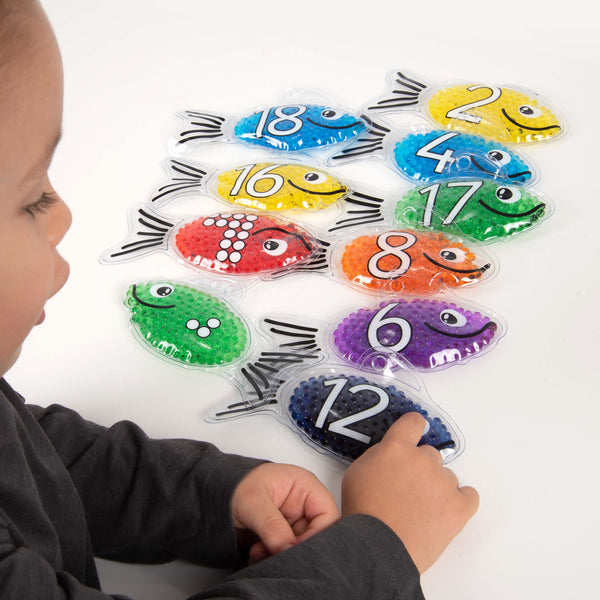 Rainbow Gel Number Fish, Vibrantly rainbow coloured Rainbow Gel Number Fish with numbers 0-20 on one side and their corresponding dots on the other. The Rainbow Gel Number Fish are Ideal for learning to count, to associate numbers with quantities, for colour recognition and for sensory play. The tactile squashy Rainbow Gel Number Fish contain gel-like beads in 7 crystal clear rainbow colours, with a loop at the top for hanging on a string or with pegs. The translucent colours contained within the Rainbow Ge